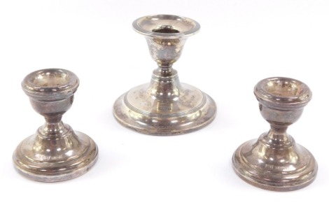 A pair of loaded silver squat candlesticks, Birmingham 1971, 5.5cm high, together with an Edward VII silver loaded candlestick, Chester 1907, 7cm high, 8.2toz all in.