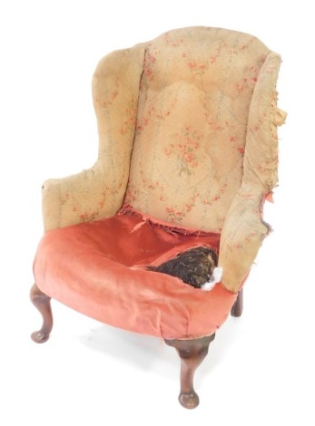 A George II mahogany framed wingback armchair, for re-upholstery, raised on cabriole legs.