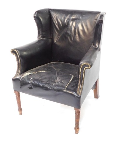 An early 19thC mahogany and studded black leather wing back armchair, raised on turned legs, 83cm wide.