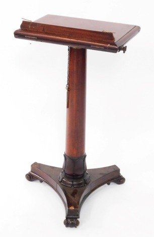 A Victorian mahogany reading lectern, raised on an adjustable turned and lappet carved column, over a triform base, raised on scroll feet, 109cm high, 46cm wide, 29cm deep.