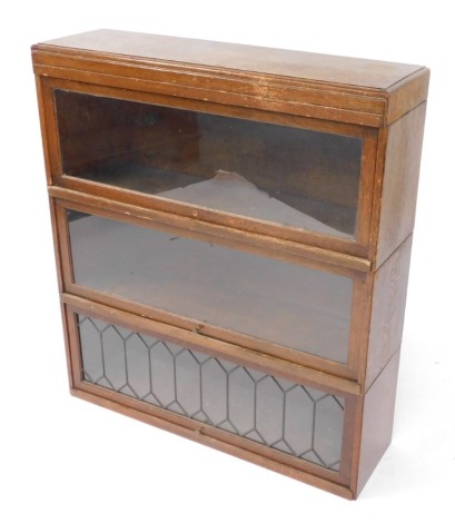 A Globe Wernicke Classic oak three section bookcase, with up and over fronts, the bottom front astragal glazed, raised on a plinth base, 95cm high, 85cm wide, 24cm deep.