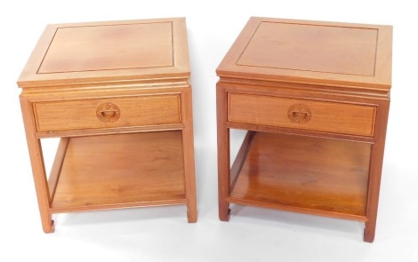 A pair of Chinese pale teak bedside tables, with a single frieze drawer, raised on tapering square legs, united by an under tier, 56cm high, 51cm diameter.