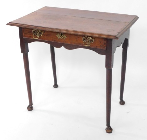 A George III oak and mahogany cross banded side table, with a single frieze drawer, raised on turned legs and bun feet, 74cm high, 79cm wide, 50cm deep.