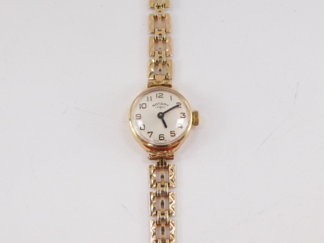 A Rotary lady's 9ct gold cased wristwatch, champagne dial bearing Arabic numerals, on a gold three bar gate bracelet strap, 13.2g all in.