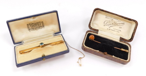 An Edwardian 9ct gold and aquamarine bar brooch, with safety chain as fitted, together with a cabochon tie pie, claw set, 5.5g.