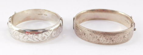 A Georg Jensen silver bangle, with engraved decoration, on a snap clasp, together with another similar English silver bangle, 1.9toz. (2)