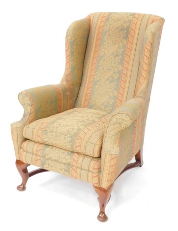 A Georgian style mahogany wing back armchair, upholstered in floral pattern and striped fabric, raised on cabriole legs, 78cm wide.