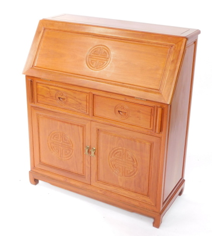 A Chinese teak bureau, the fall flap opening to reveal a single drawer flanked by six recesses, above two frieze drawers above cupboard doors, raised on bracket feet, 104cm high, 94cm wide, 43cm deep.