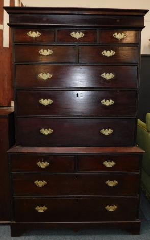 A George III oak chest on chest, the out swept pediment over a semi secret long drawer, over three short, two medium and three long graduated drawers, above two short and two long further drawers, raised on bracket feet, 178cm high, 104cm wide, 55.5cm dee