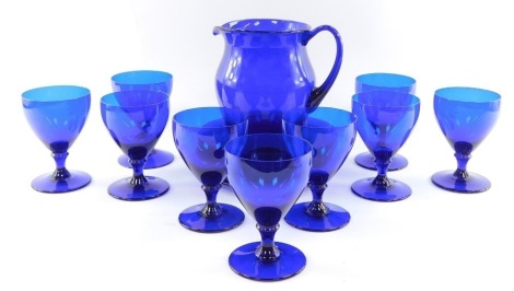 A set of nine Bristol type blue glass rummers, together with a blue glass water jug, and eight plates.