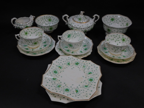 An early 19thC porcelain part tea service, decorated in green and yellow with flowers, within gilt rings, pattern no 21, painted mark, comprising cream jug, sucrier, two slop bowls, pair of bread plates, three breakfast cups, saucers and plates. (AF)