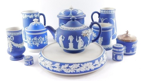 Wedgwood and other dark blue Jasperware, decorated with classical figures, floral festoons, etc., including a tobacco jar, biscuit barrel, cover and stand, two jugs and a teapot. (AF). (a quantity)