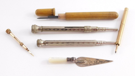 A silver and mother of pearl handled trowel form page marker, three propelling pencils, and a gold plated toothpick.