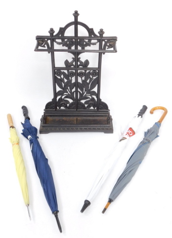 A Coalbrookdale black cast iron stick stand, with a two division drip tray, containing four umbrellas, bears registration lozenge, 73.5cm high, 47cm wide.