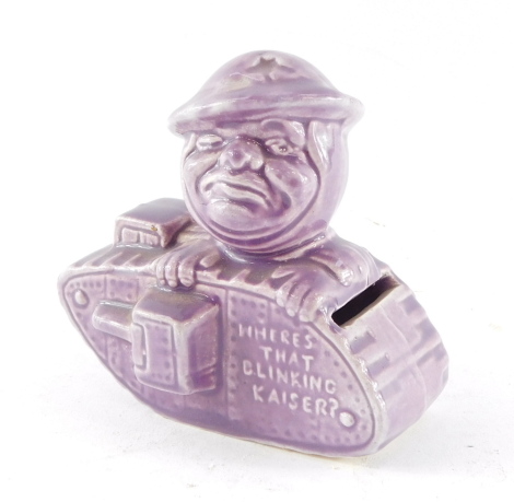 An early 20thC Old Bill pottery money box, after Bruce Bairnsfather, modeled as a soldier in a tank 'Where's That Blinking Kaiser', lilac ground, 10cm wide.