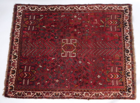 A Caucasian red ground rug, decorated with geometric motifs, 150cm x 120cm.