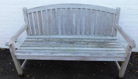 A slatted garden bench with shaped arched back, on block supports joined by vertical stretchers, 150cm.