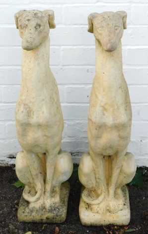 A pair of reconstituted stone figures of greyhounds, modelled seated on a square base, 76cm high.