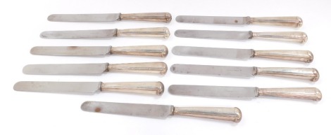 A set of eleven George III silver pistol handle table knives, crest engraved with later blades, Moses Brent, London 1791.