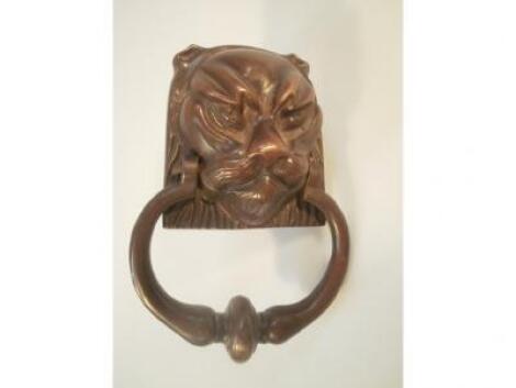 A Bronze door knocker in the shape of a lions head