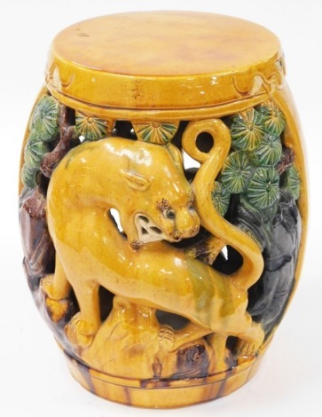 An early 20thC yellow green and brown glazed Chinese barrel seat, decorated with lions and trees, unmarked, 38cm high, approx 27cm wide.