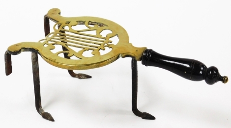 A 19thC Irish brass trivet, of Longfields patent type, with pierced lyre foot plate and prong attachment and an ebony handle, 35cm long.