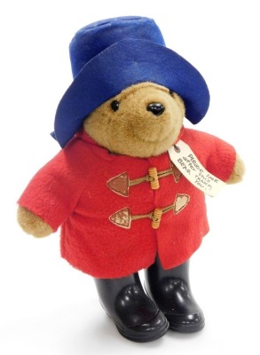 A Paddington Bear, with blue hat and red duffel coat with black wellingtons, 35cm high.