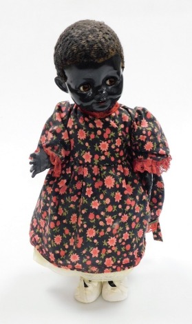 A Pedigree Afro Caribbean doll, in a floral dress, with cream shoes, 39cm high.