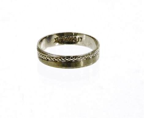 A platinum wedding band, with half hammered design, the other bark effect detailing, marked PT990, ring size P½, 3.9g all in.