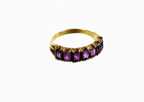 An amethyst set dress ring, of half hoop design with oval cut amethyst in claw setting with V splayed inverted shoulders, yellow metal unmarked, ring size O, 2.5g all in.