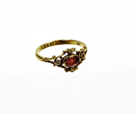 A 9ct gold dress ring, with central design of an oval ruby, in a rub over setting, with pierced and open work flower four point design each set with tiny diamond, ring size M½, 2g all in.