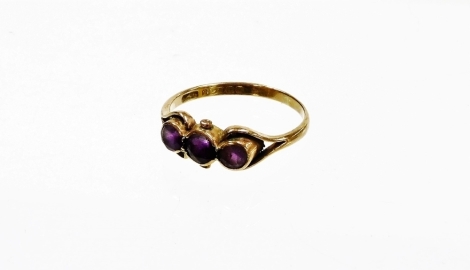 A 9ct gold amethyst dress ring, with three amethysts in rub over setting with pierced and open work shoulders, ring size P, 1.7g all in.