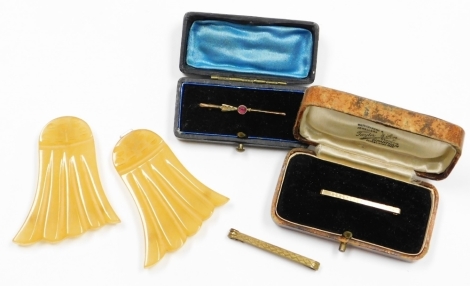 A small group of jewellery, to include a 9ct gold bar brooch set with ruby, 0.9g, one plated bar brooch, a 9ct gold bar brooch with etched design and a Bakelite nurses buckle in the Art Deco style. (4)