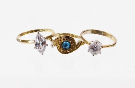 Three various dress rings, to include two single stone diamond simulates, each gold coloured but stamped 925, and a further twist design dress ring stamped 925. (3)