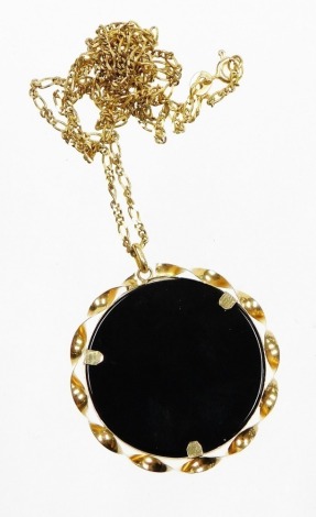 A 9ct gold pendant and chain, the circular pendant set with black agate stone, in a 9ct gold twist surround, on a Byzantine longuard chain, the pendant 4cm diameter, the chain 72cm long overall, 11.2g all in.