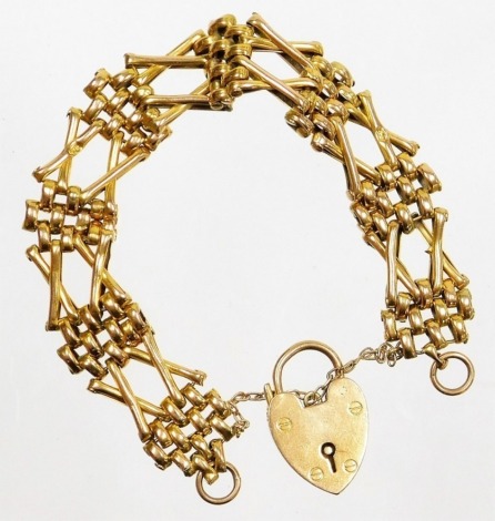 A 9ct gold gate bracelet, of four row and two row cross link design, with safety chain and a heart shaped padlock, 16cm long, 17.5g.