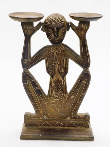 Tribal Art. A carved wooden figure holding two bowls, 51cm high, 30cm wide.