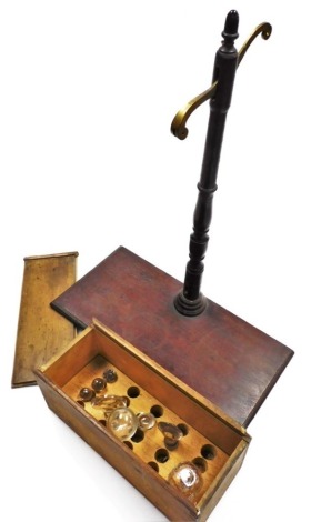 A group of items, to include a weighing scale stand lacking strings and balance, with lion weight, and a wooden box with various decanter stoppers.