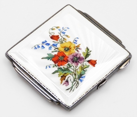 A George V silver and enamel compact, the square front with cream enamel and painted detailing of pansies and bluebells, opening to reveal mirror and powder section, Birmingham 1939, 7cm x 7.5cm, 3oz gross.