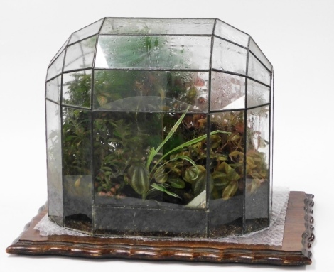 A terrarium, with domed and lead applied top, on a later mahogany fluted base, the dome, 42cm high, 44cm wide and approx 27cm deep, the base 60cm x 43cm. (AF)