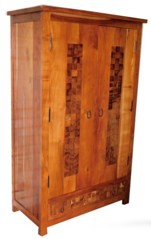 A hardwood double wardrobe, by Acia Wood, the doors with applied panelling and metal swing handles, with two cupboard doors and single drawer to base, 180cm high, 110cm wide, 55cm deep.