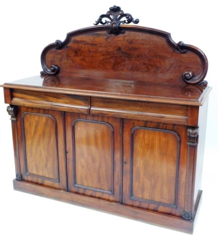 A Victorian mahogany sideboard, the carved panelled back above two drawers and three cupboard door section, 152cm wide, 159cm high, 52cm deep.