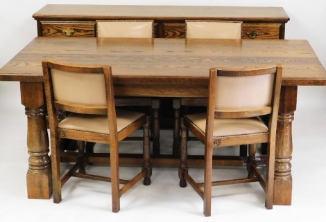 An oak dining room suite, comprising a refectory table and four dining chairs with button upholstered seats and associated sideboard, the table 78cm high, 182cm wide, 91cm deep, the sideboard with four drawer top and four cupboard door base, with brass ha