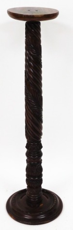 A carved mahogany plant stand, with leave carved detailing on circular foot, 116cm high, 26cm wide.