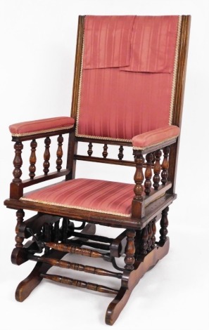 An American rocking chair, with later upholstered pink striped material, with walnut beading, 107cm high, 56cm wide, 50cm deep.