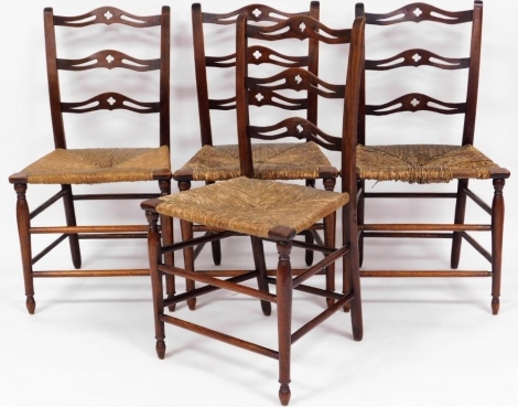 A set of four oak Arts & Crafts rush seated chairs, each with three splayed carved panel back on rush seat.