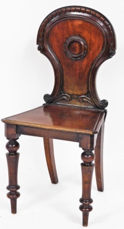 A Victorian mahogany hall chair, with carved shield back with central shield emblem, on tapered legs, 85cm high, 43cm wide, 37cm deep. (AF).