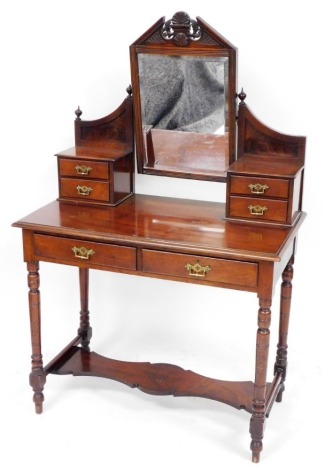 A Victorian walnut dressing table, with carved fan mirrored centre above two pedestal sections with two drawers, on a block base with two pull out drawers with brass handles on tapered legs.