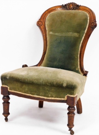 An Edwardian walnut nursing chair, with carved supports upholstered in green draylon, with cream ribbed borders, 100cm high, 54cm deep, 56cm wide.