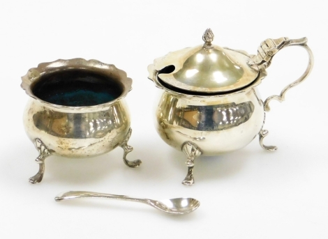 Two silver salts, to include an Oxford silver salt with flared rim on tripod shelf feet, Chester 1841, together with a silver mustard 1841, with blue glass liner and silver plated military spoon, 4¾oz gross.